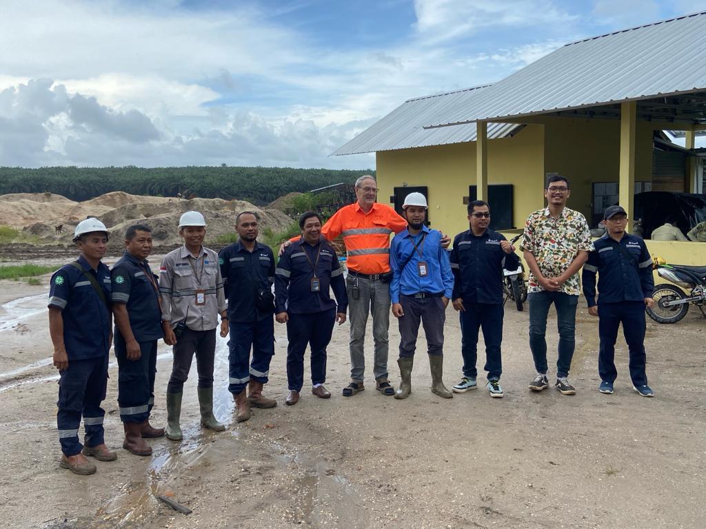 Team photo at a mining site in Indonesia with safety gear
